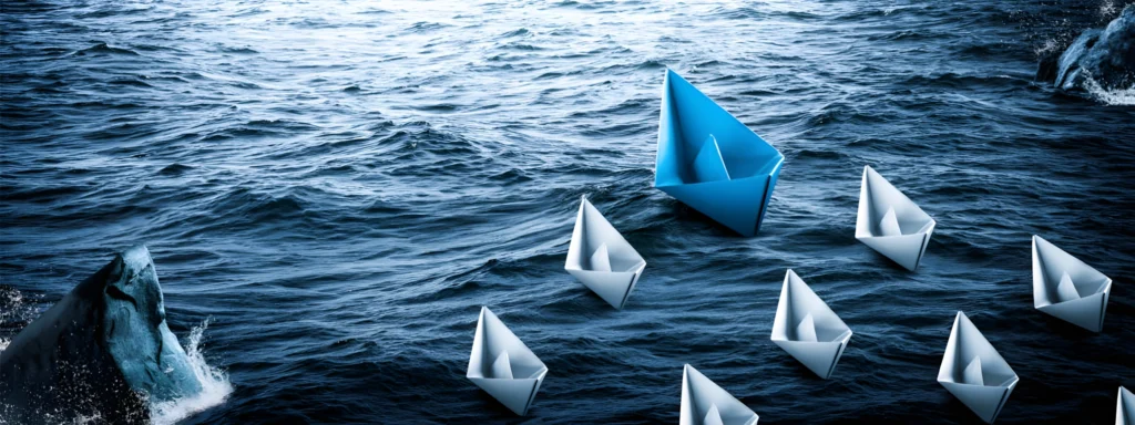 Symbolische Papierboote auf offenem Meer zeigen ein führendes Schiff an der Spitze und verdeutlichen moderne Prinzipien effektiver Mitarbeiterführung.