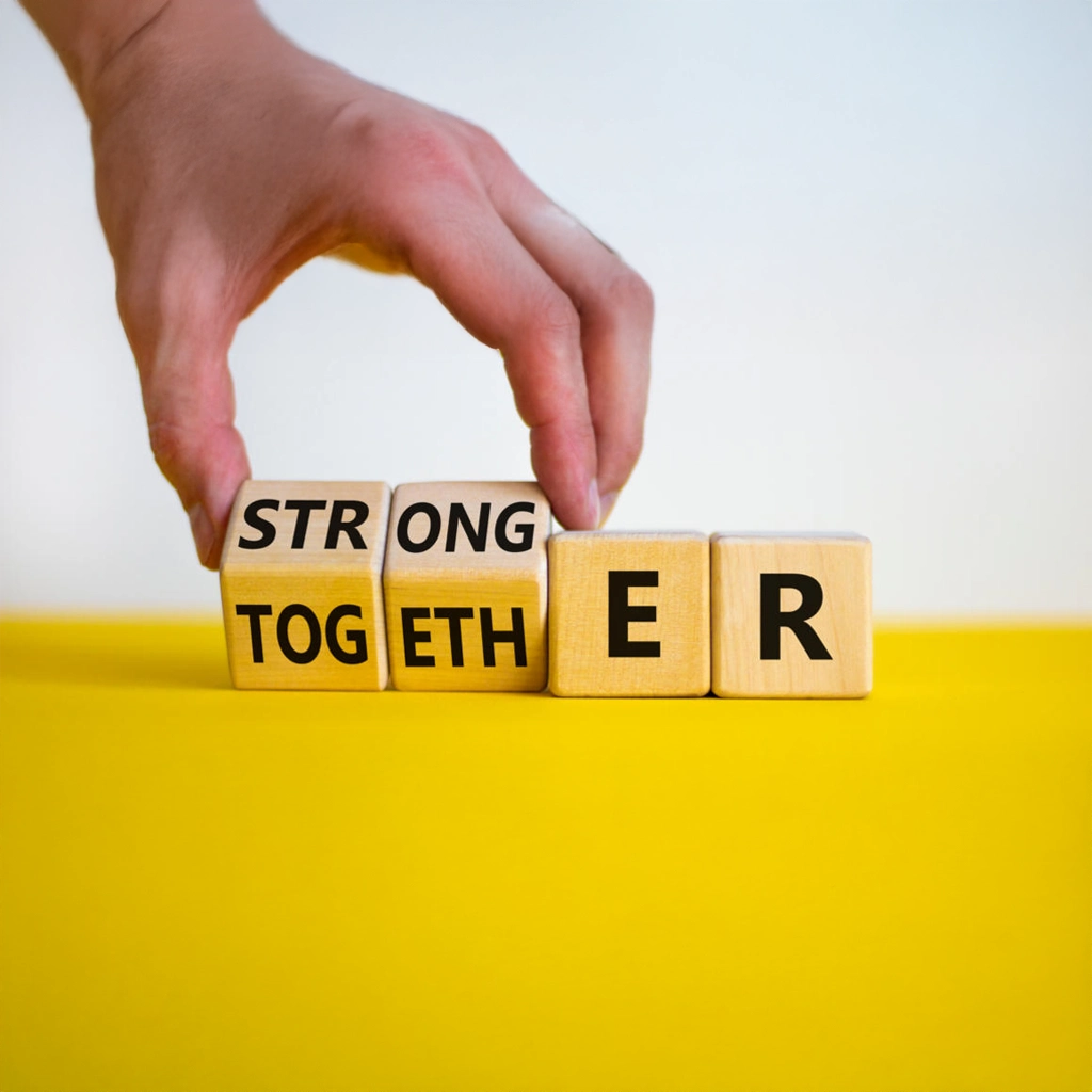 Holzwürfel formen den motivierenden Schriftzug ‚Stronger Together‘ und symbolisieren kraftvolle Zusammenarbeit im Rahmen eines wirksamen Teambuilding Workshops.