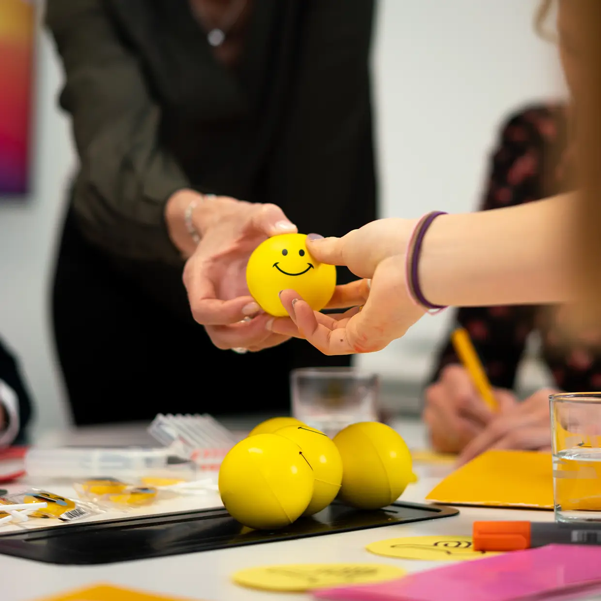Workshop zur Kundenbegeisterung: Teilnehmende arbeiten mit gelben Smile-Bällen als Symbol für positive Servicehaltung und emotionale Gästeansprache.