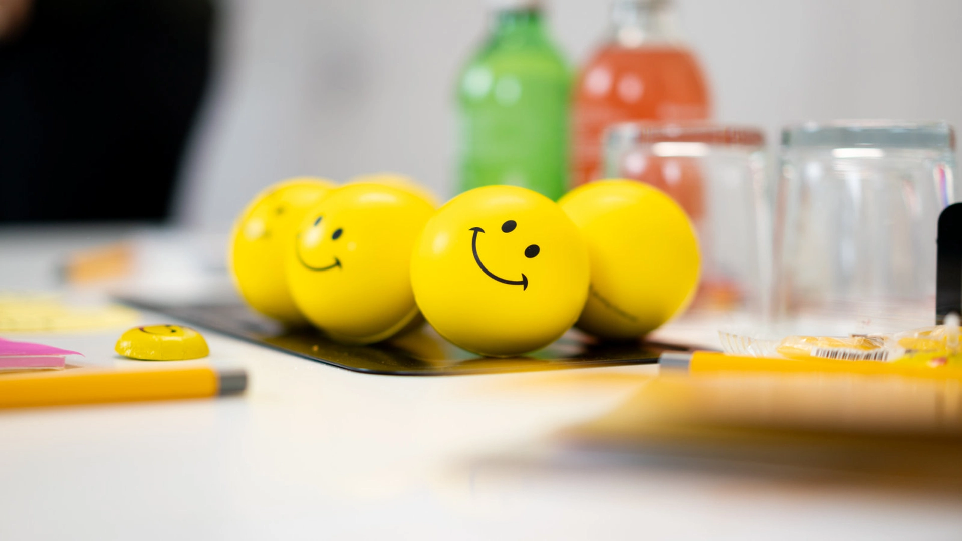 Gelbe Smiley-Stressbälle auf einem Coaching-Tisch bei Smiling Customer, genutzt für Trainings zu Servicequalität und Kundenbegeisterung.