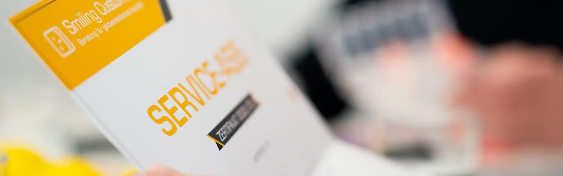 Unterlagen mit der Aufschrift ‚Service‘ werden durchgeblättert und symbolisieren die strukturierte Vorbereitung eines professionellen Service Trainings.